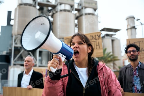 Preview: Angry and rebellious woman speaking and protesting with megaphone at demonstration at climate change
