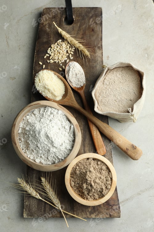 Preview: Different types of flour on light grey table, flat lay
