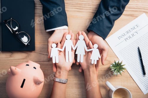 Preview: top view of lawyer and woman holding paper cut family near cup of coffee, insurance policy