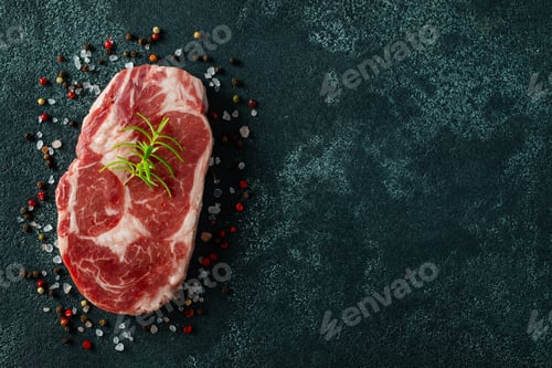 Preview: Raw fresh meat Ribeye Steak and seasoning on dark background. Top view with copy space. Flat lay