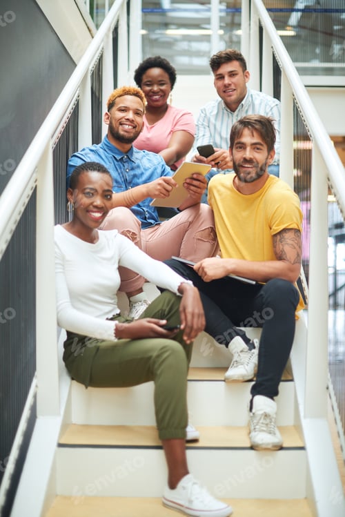 Preview: Portrait of a group of confident young businesspeople sitting on the steps of a modern office