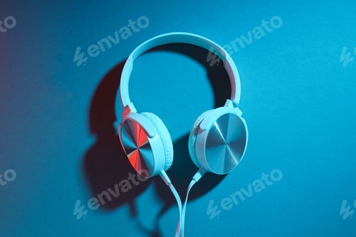 Preview: White, over-the-ear headphones with a wire on a colored, dark background.