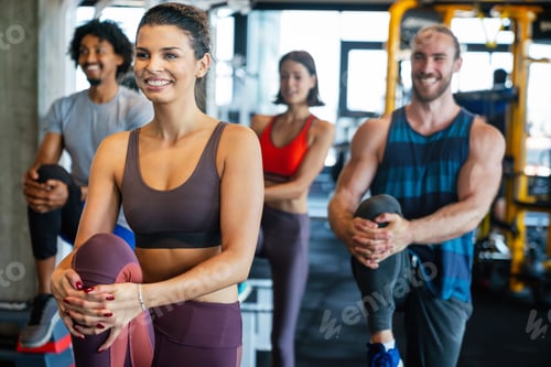 Preview: Group of young people doing exercises in gym