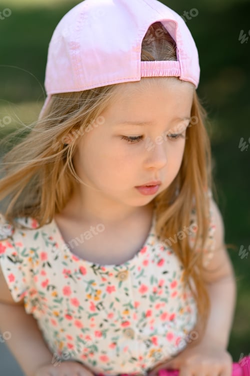 Preview: Little girl 3 years old in a pink cap. Close-up. Summer time.