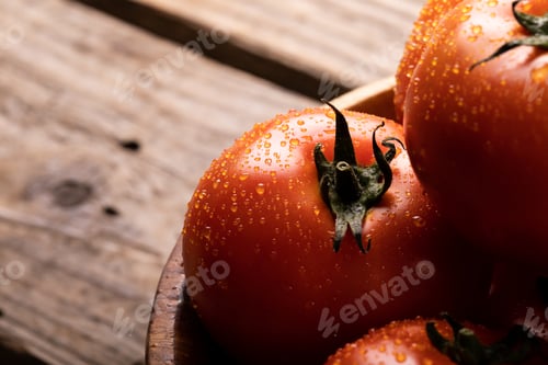 Preview: High angle close-up view of water drops on fresh red tomatoes in bowl on table