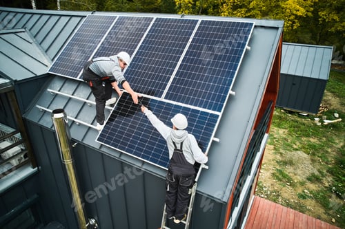 Preview: Men workers installing solar panels on roof of house.