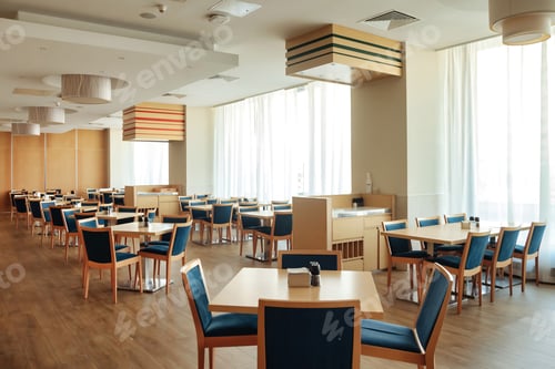 Preview: Large empty dining room with tables and chairs is brightly illuminated