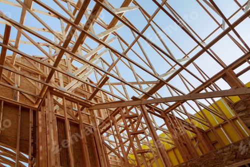 Preview: New construction home framing against blue sky, closeup of ceiling frame