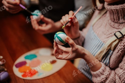 Preview: Creative hands painting colorful easter eggs together