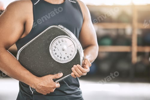 Preview: Hand of a fit man holding a scale. Strong man measuring his weight at the gym. Bodybuilder carrying