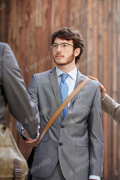 Preview: Businessmen shaking hands in courtyard