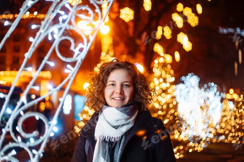 Preview: curly young woman in night festive lights