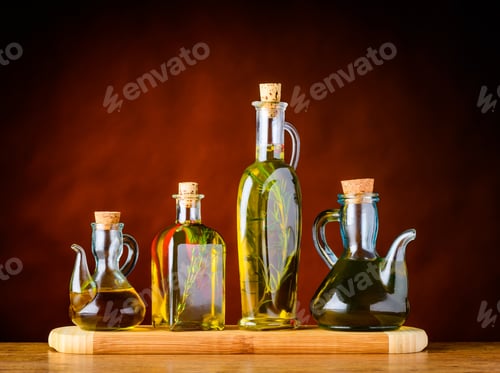 Olive Oil Infusions in Glass Bottles on Wood