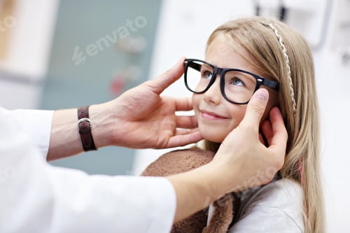Preview: Child male optometrist examines eyesight of little girl