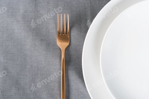 Preview: top view of arranged tarnished old fashioned fork and empty plates on tabletop