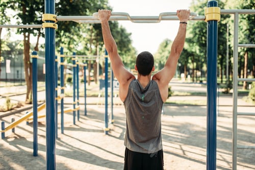 Preview: Man doing exercise on horizontal bar outdoor