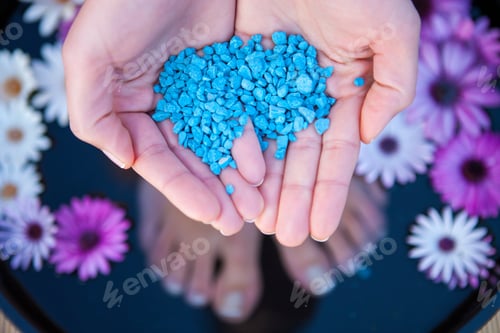 Preview: Woman standing in foot bath, holding salt crystals, overhead view