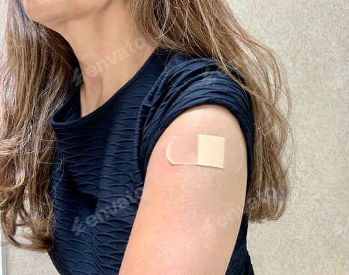 Preview: Woman with band-aid on her arm after getting her Covid19 vaccine. Immunization fighting coronavirus