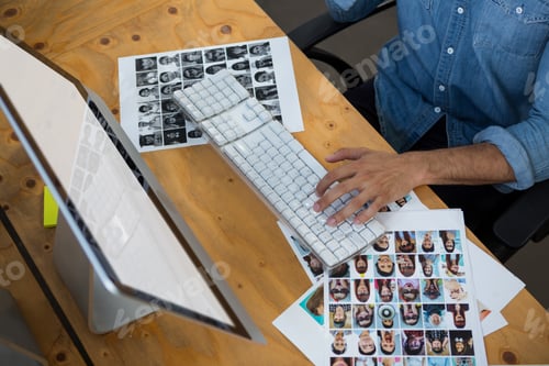 Visualização: Homem com fotografias trabalhando no PC desktop