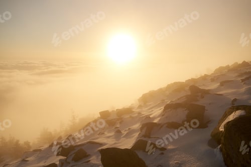Preview: Sunrise over snow-covered mountain peak.
