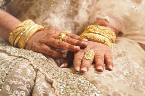 Preview: Elegant hands adorned with gold jewelry and intricate henna design