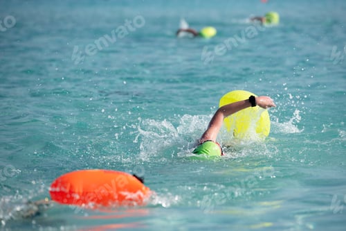 Preview: Athletes swimming free style in the sea during triathlon competition. Swimmer in the ocean