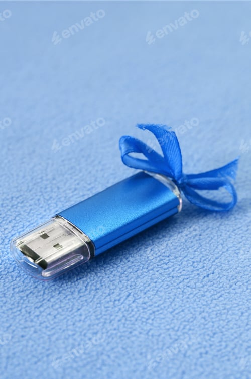 Preview: Brilliant blue usb flash memory card with a blue bow lies on a blanket of soft and furry