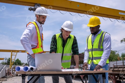 Preview: Engineers wearing safety helmets and reflective vests working site large overhead crane