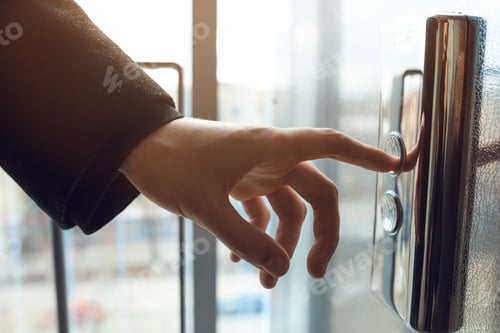 Preview: Man pressing elevator button. finger presses the elevator button. Red button. sunset light.
