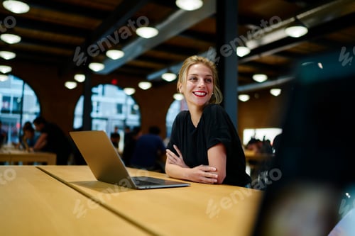 Preview: Happy woman with laptop in cafe