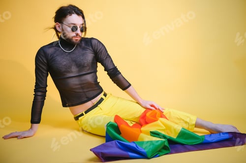 Preview: Youth transgender LGBT with Rainbow flag on shoulder isolated color background.