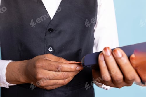 Preview: Hotel concierge with suit and tie presenting the card and pos terminal