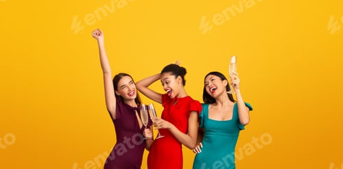Preview: Three Girls Celebrating Drinking Sparkling Wine And Dancing, Yellow Background