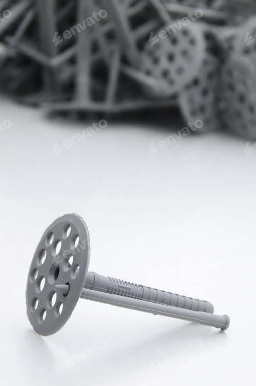 Preview: A gray plastic dowel fastening for thermal insulation with round umbrella caps lies on a gray