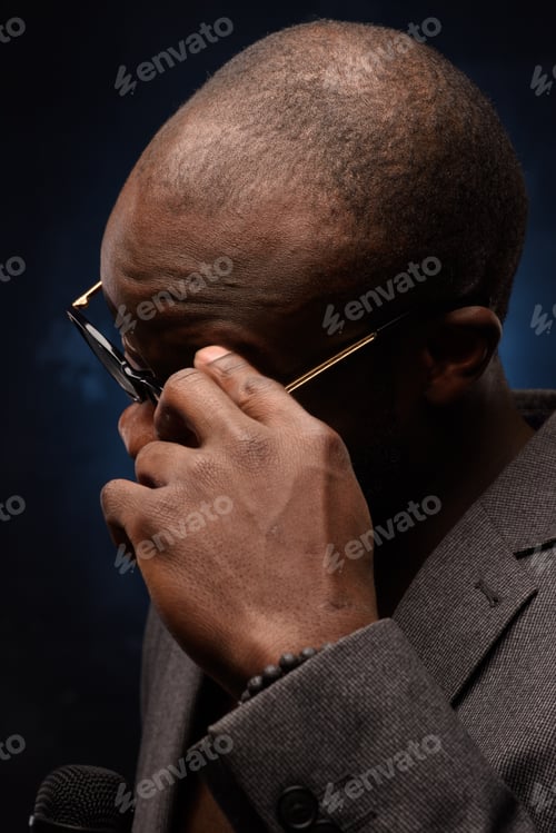 Preview: Close up portrait of young african man isolated on black studio background.