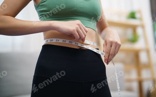 Preview: Woman Measures Waist in an Indoor Setting