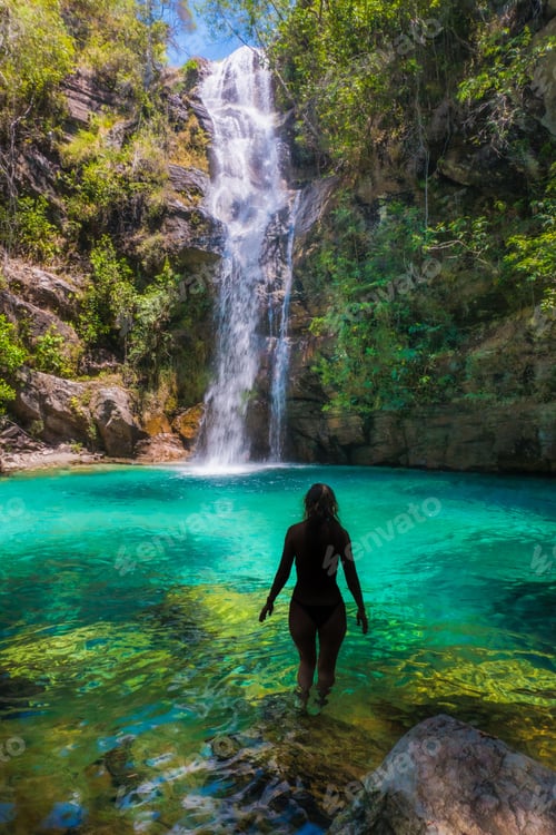 Preview: Woman in a picturesque landscape, walking through the shallow waters of a tropical paradise