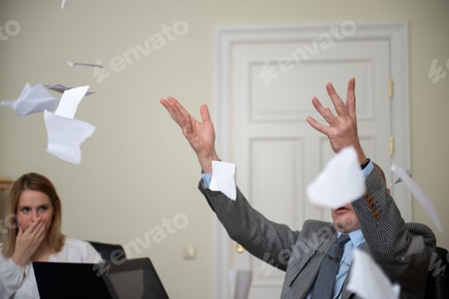 Preview: An angry senior man tears a document during a business meeting in a conference room