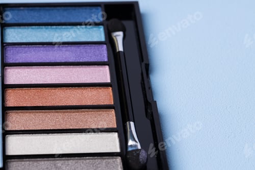 Preview: Set of eyeshadows on blue background close up