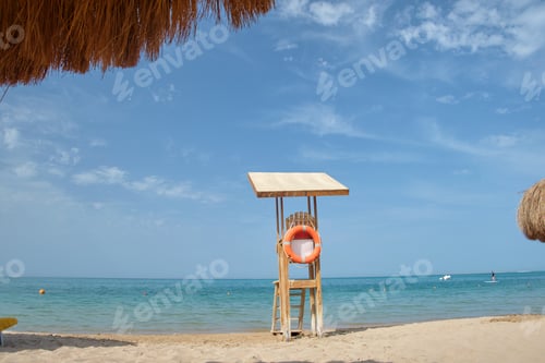 Preview: Emplty wooden lifeguard station on sandy beach on ocean shore in summer