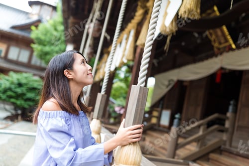 Preview: Woman wishing and ringing the bell in Japanese