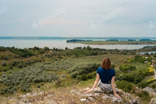 Preview: Woman sitting on rock enjoying the view