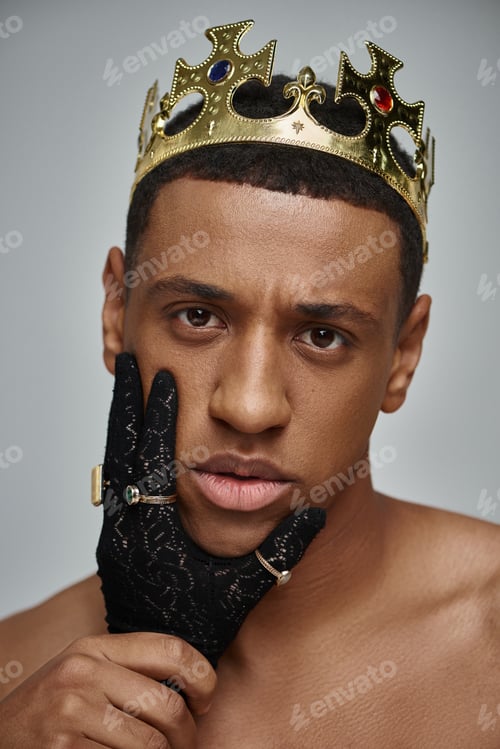 Preview: female hands in black gloves with rings near face of shirtless african american man with crown