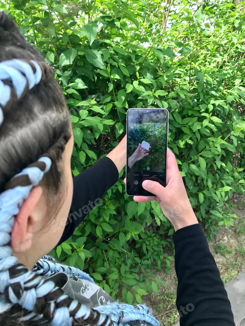 Preview: A girl with blue braids using white Smartphone. || Outdoors || Natural light || Outside || Hand