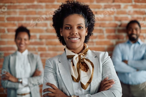 Preview: Young black female leader with her business team in the background.
