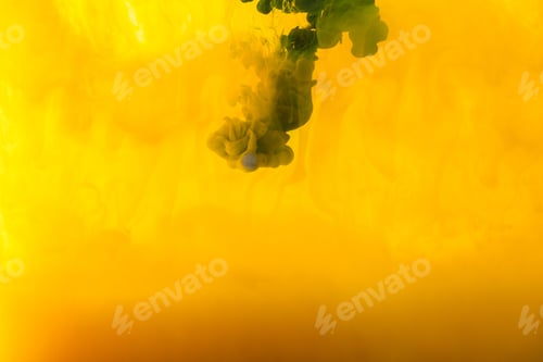 Preview: full frame image of mixing of yellow and green paints splashes in water