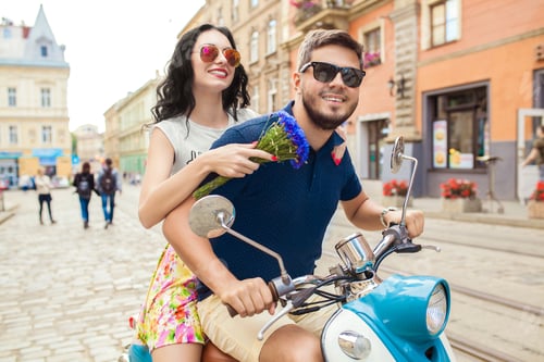 Preview: young beautiful hipster couple riding on motorbike city street