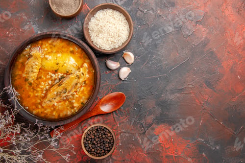 Preview: top view chicken soup bowls with pepper rice garlic spoon on dark red background with copy space