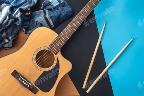Preview: Music background with guitar and drumsticks, top view.