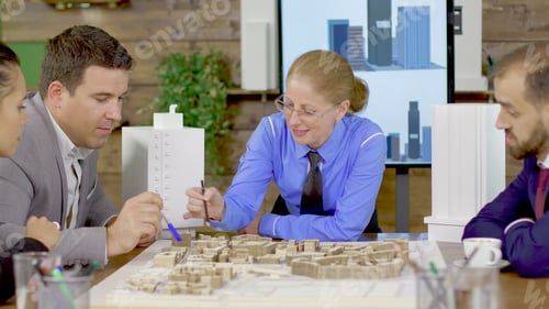 Preview: Middle age female architect in a meeting with his team in the conference room